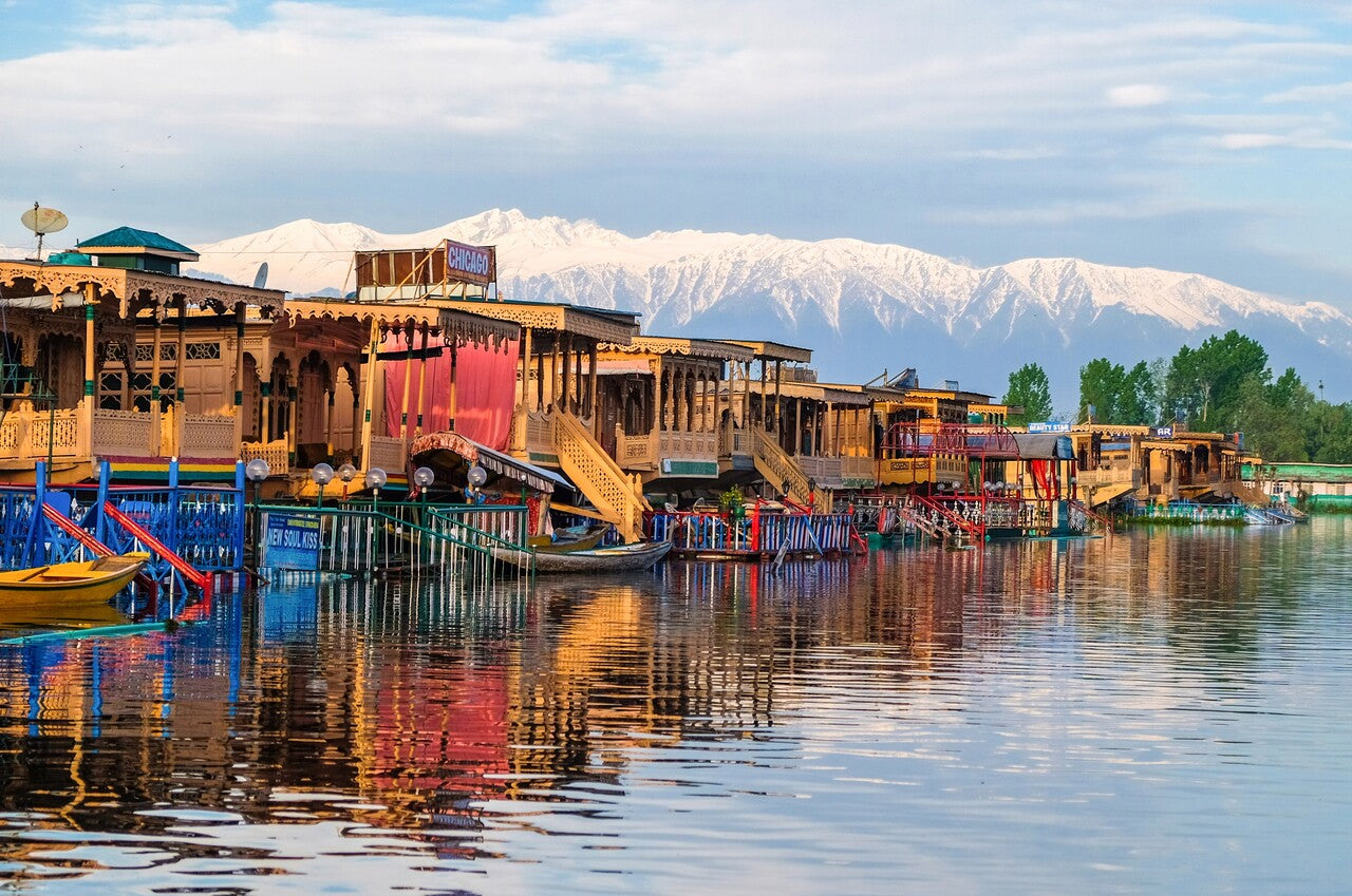 Colorful riverfront homes with snowcapped mountains in the background.