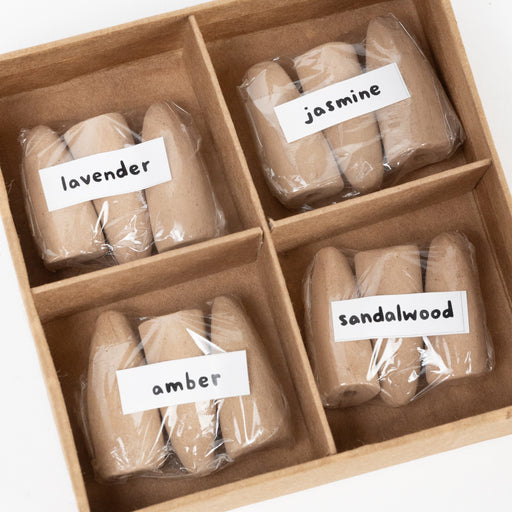 Four compartment kraft box showing 12 incense cones. Three cones of each scent: amber, jasmine, lavender, and sandalwood.