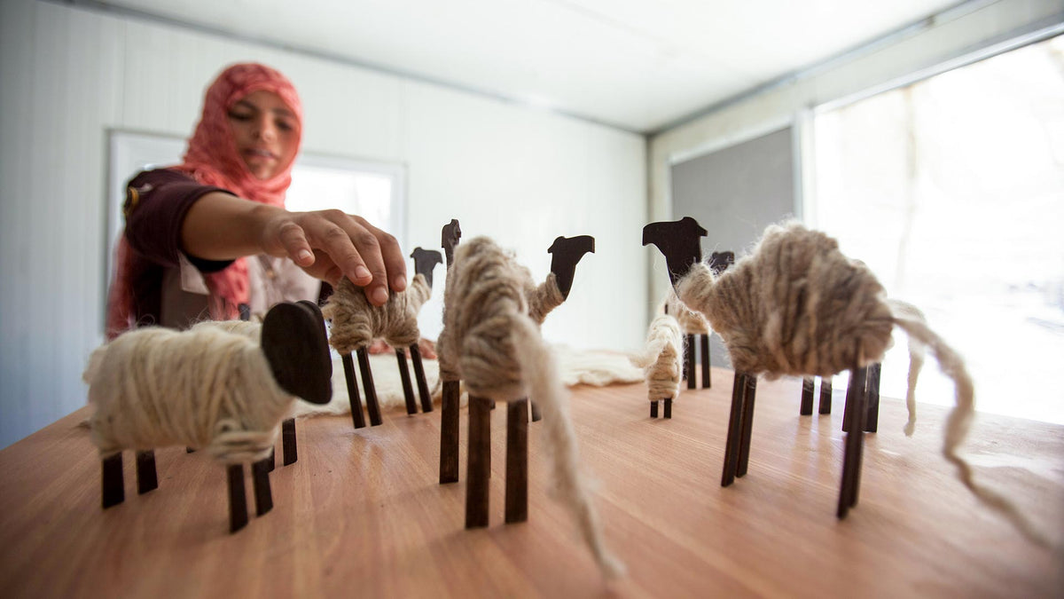 A woman artisan of BFTA crafts camel ornaments.
